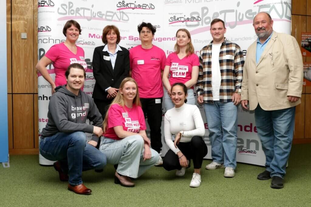 Eine Gruppe von Menschen vor einem Werbebanner der MSJ